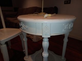 Mesa auxiliar blanca con lámpara y silla