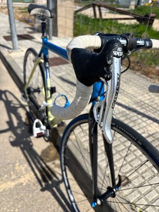 Bicicleta carretera Decathlon azul y crema.