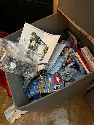Cubo de piezas y manuales LEGO