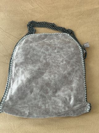 Bolso gris con cadenas plateadas.