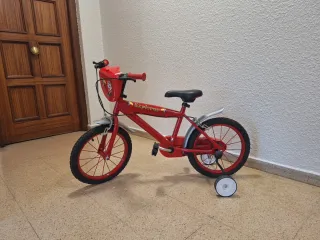 Bicicleta roja con ruedines.