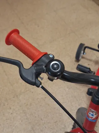 Bicicleta roja con ruedines.