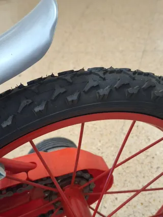 Bicicleta roja con ruedines.