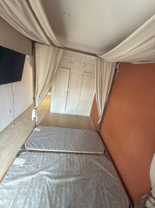 Cama con dosel de madera y tela