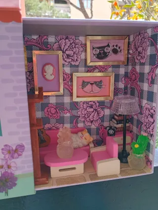 Casa delle bambole con mobili e gattino in salotto