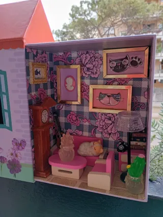 Casa delle bambole con mobili e gattino in salotto