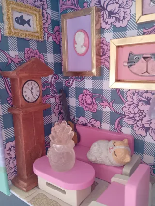 Casa delle bambole con mobili e gattino in salotto
