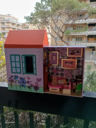 Casa delle bambole con mobili e gattino in salotto