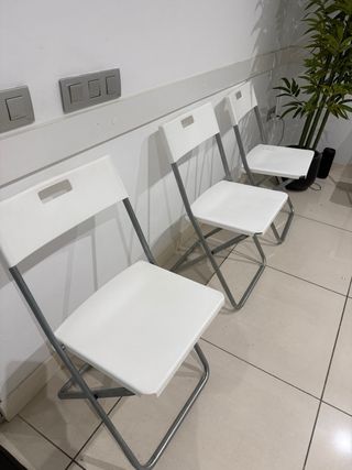 Silla plegable blanca y plateada