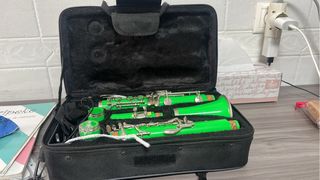 Clarinete plástico verde con estuche.