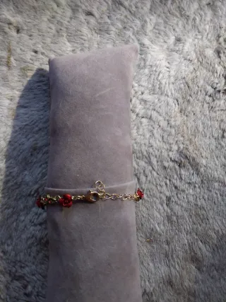 Pulsera dorada con rosas rojas