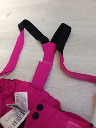 Pantalón de esquí rosa con tirantes y guantes