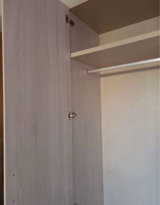 Armario de madera beige con tiradores verdes