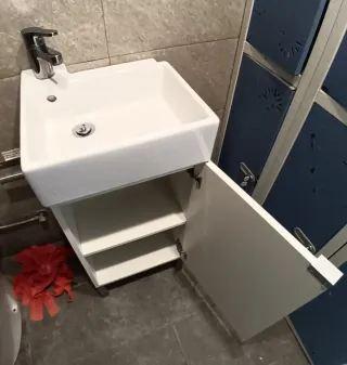 Lavabo de cortesía con grifo y mueble color blanco