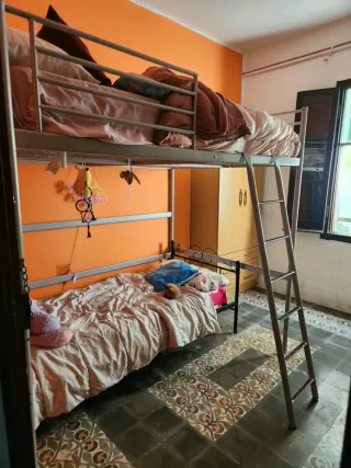 Cama alta, con somier.