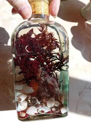 Candela decorativa con conchiglie e rami di fiore