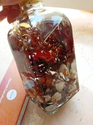 Candela decorativa con conchiglie e rami di fiore