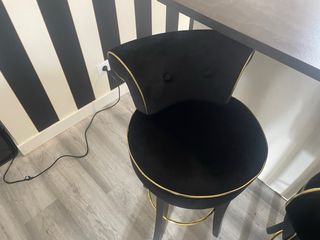 Sillas de terciopelo negro con detalles dorados.