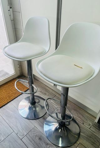 Taburetes blancos con base metálica