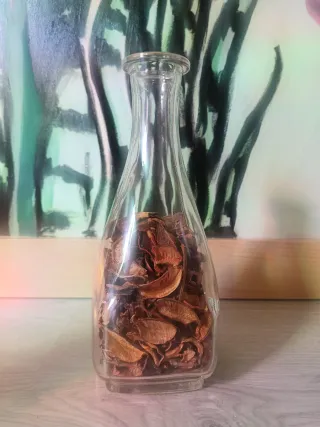 Botella de vidrio con flores secas