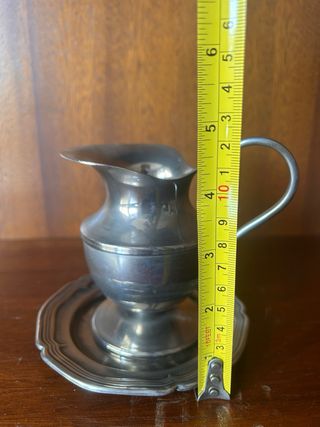 Jarra de metal plateada con plato