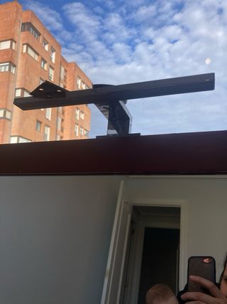 Espejo de madera marrón con luminaria superior