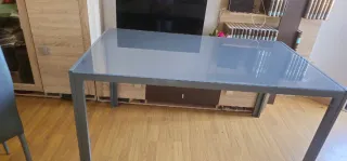Mesa de cristal con marco metálico gris