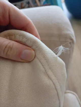 Sofá de tela beige con cojines