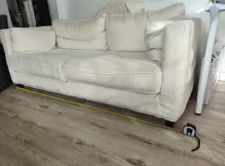 Sofá de tela beige con cojines