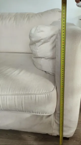 Sofá de tela beige con cojines