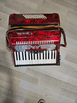 Acordeón rojo Ginelli con correas, tiene 60 bajos.