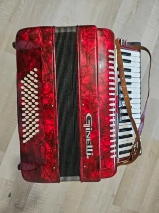 Acordeón rojo Ginelli con correas, tiene 60 bajos.