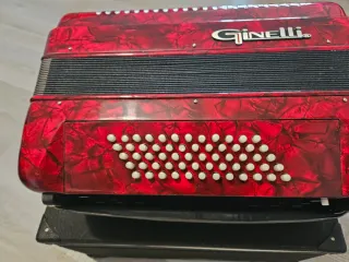 Acordeón rojo Ginelli con correas, tiene 60 bajos.