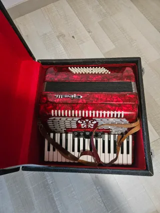 Acordeón rojo Ginelli con correas, tiene 60 bajos.