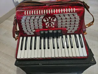 Acordeón rojo Ginelli con correas, tiene 60 bajos.