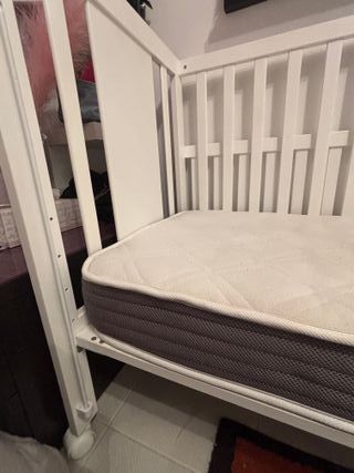 Cuna de bebé blanca con osito.