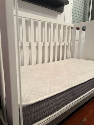 Cuna de bebé blanca con osito.