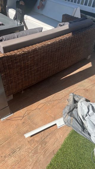 Sofá de mimbre con cojines grises impermeables.