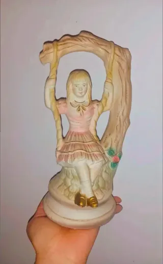 Figura de porcelana muñeca columpio