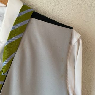 Chaleco gris con camisa blanca y corbata verde