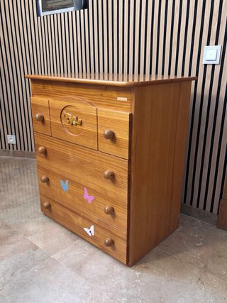 Cómoda de madera con cajones y tapa.