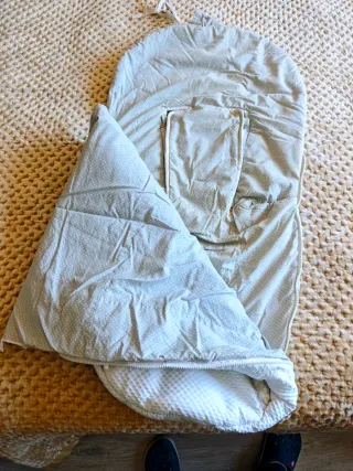 Saco de bebé azul con diseño de oruga