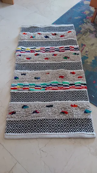 Alfombra pequeña beige con detalles multicolor