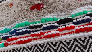 Alfombra pequeña beige con detalles multicolor