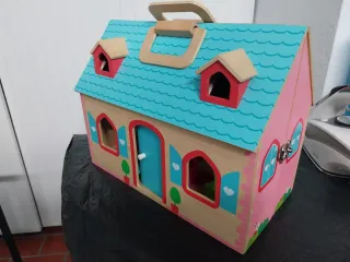 Casa de muñecas de madera con tejado azul