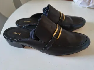 Zuecos de piel ARKHE negros con detalle dorado