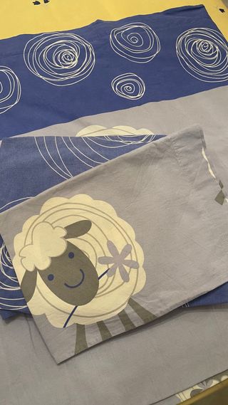 Juego de sábanas azul y gris con dibujo de ovejas.
