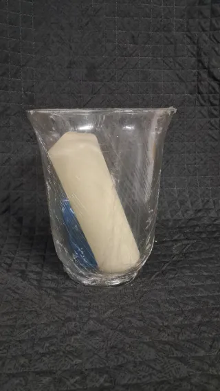 Jarrón de cristal transparente con vela y piedras