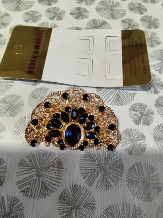 Broche dorado con piedras negras