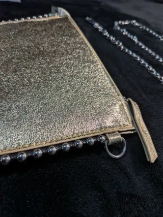 Bolso de mano dorado con cadena